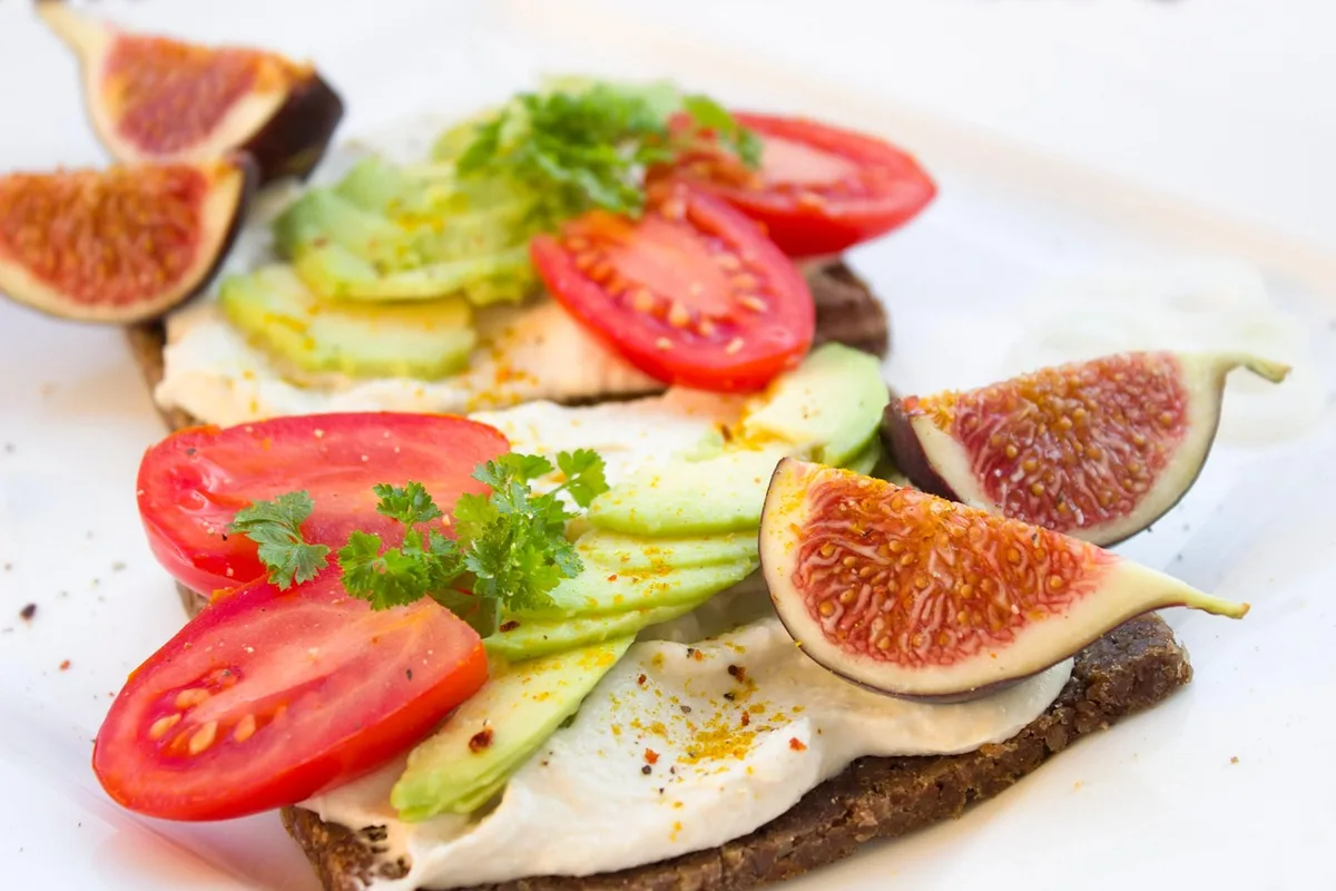 Pain complet et légumes frais préparés pour un sandwich équilibré.
