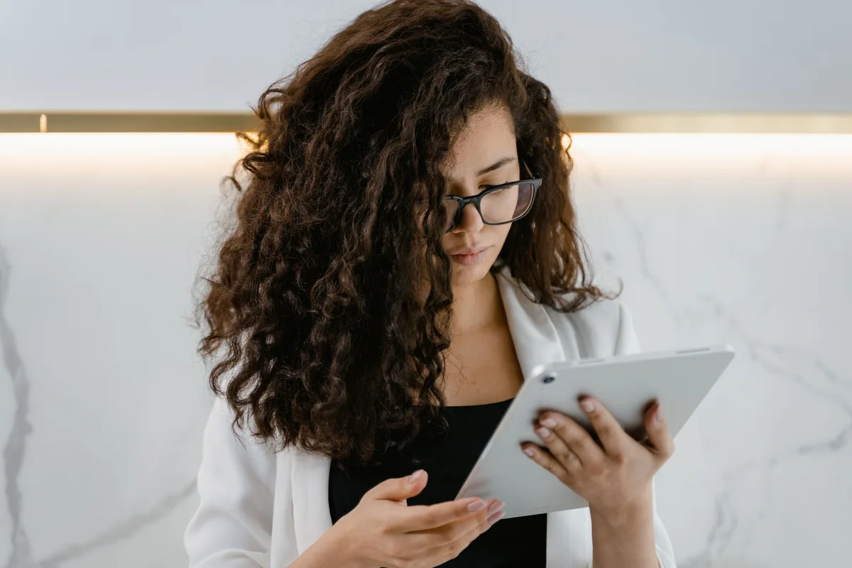 Personne montrant des photos de cheveux frisés à un coiffeur