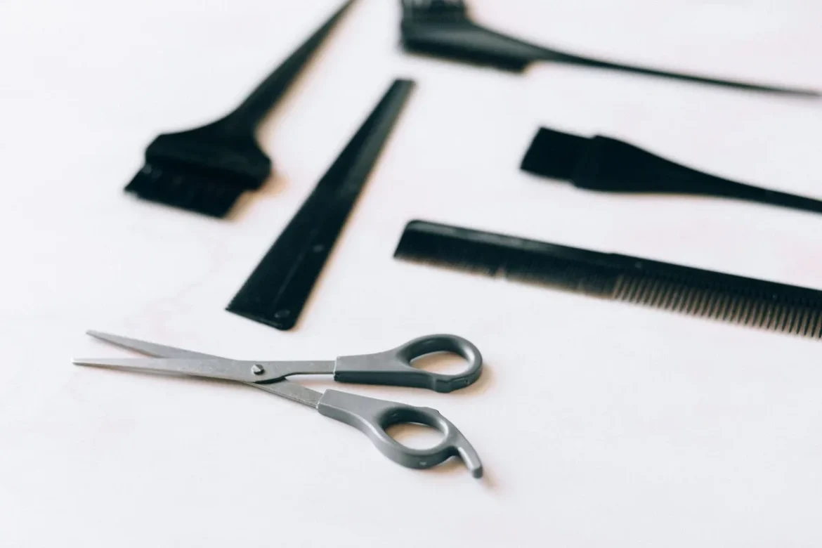 Coiffeur coupant des cheveux frisés aux ciseaux dans un salon