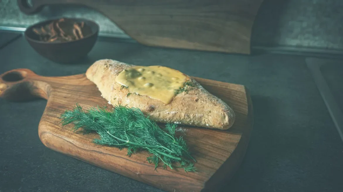 Fromage au lait cru tranché sur une planche en bois dans une cuisine
