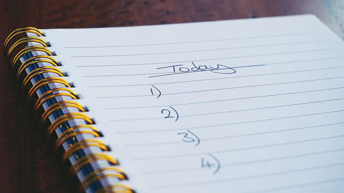 Bloc-notes avec une checklist de préparation et d'organisation du congé maternité.