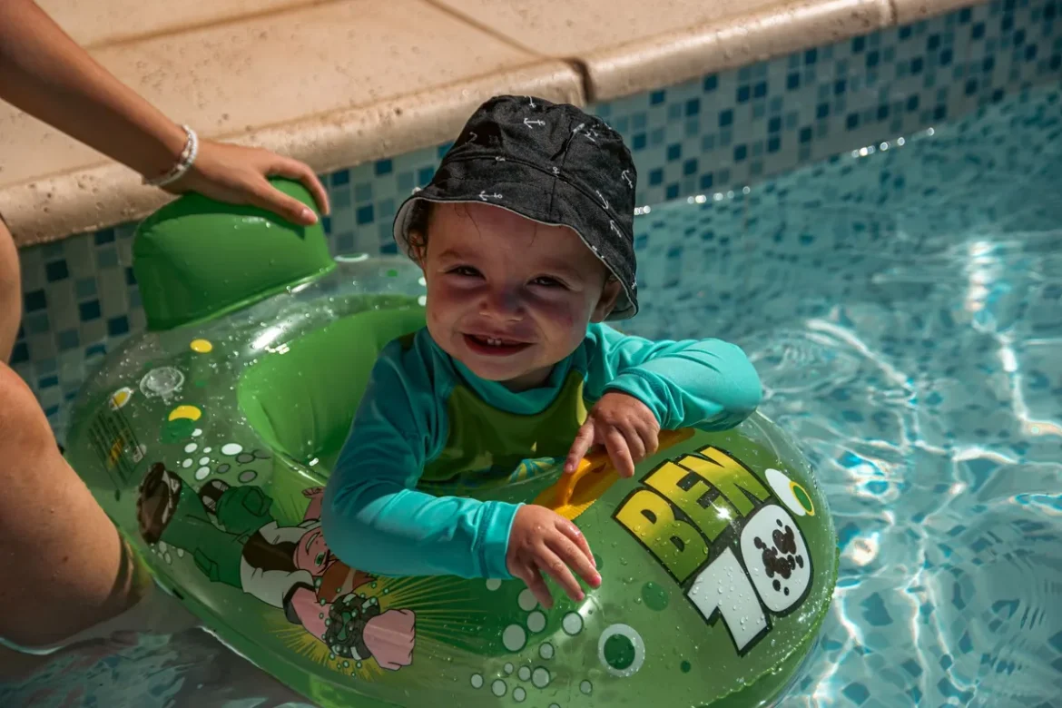 Enfant près d'une piscine avec un adulte superviseur en arrière-plan