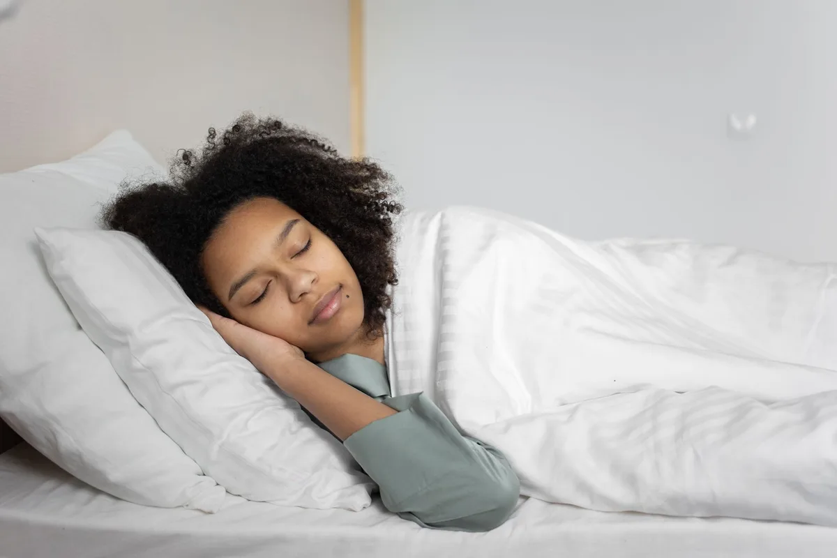 Femme dormant paisiblement, illustrant l'importance du sommeil pour la santé digestive