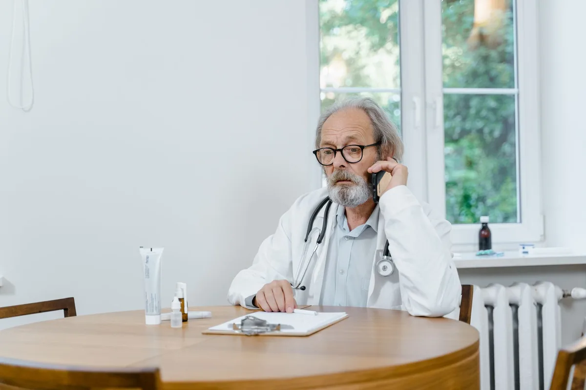 Consultation médicale entre un patient et un professionnel de santé discutant des symptômes