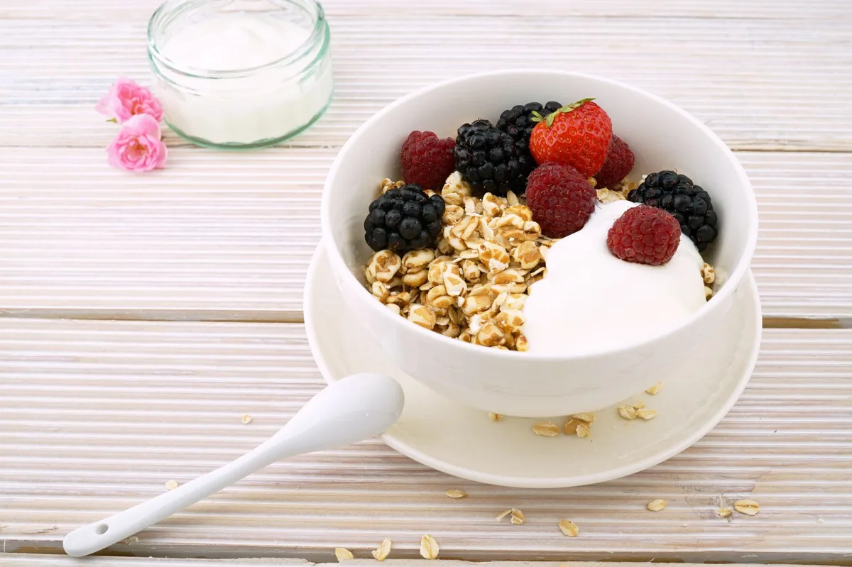 Petit-déjeuner équilibré avec yaourt nature, fruits frais et céréales complètes