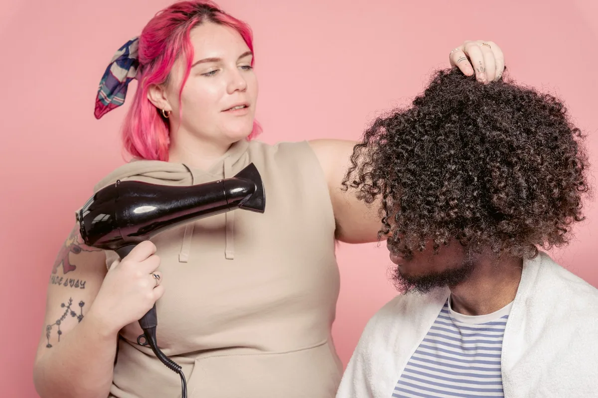 Cheveux bouclés humides en train d'être froissés pour définir les boucles