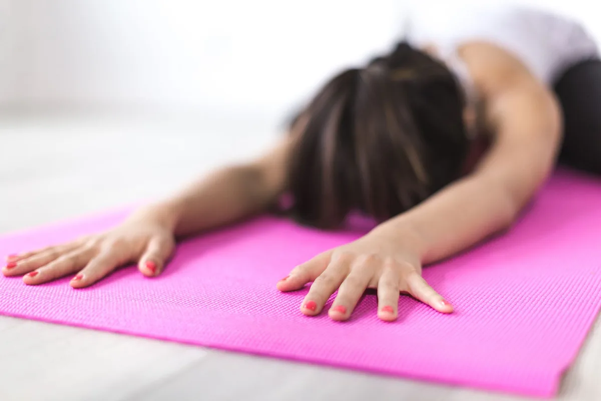 Femme pratiquant le yoga et la respiration consciente pour réduire le stress et l'anxiété