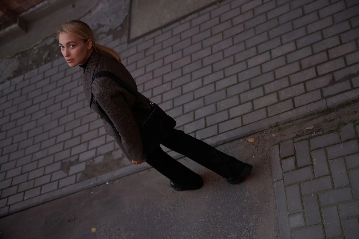 Femme portant un blazer structuré avec des détails aux épaules et au col.