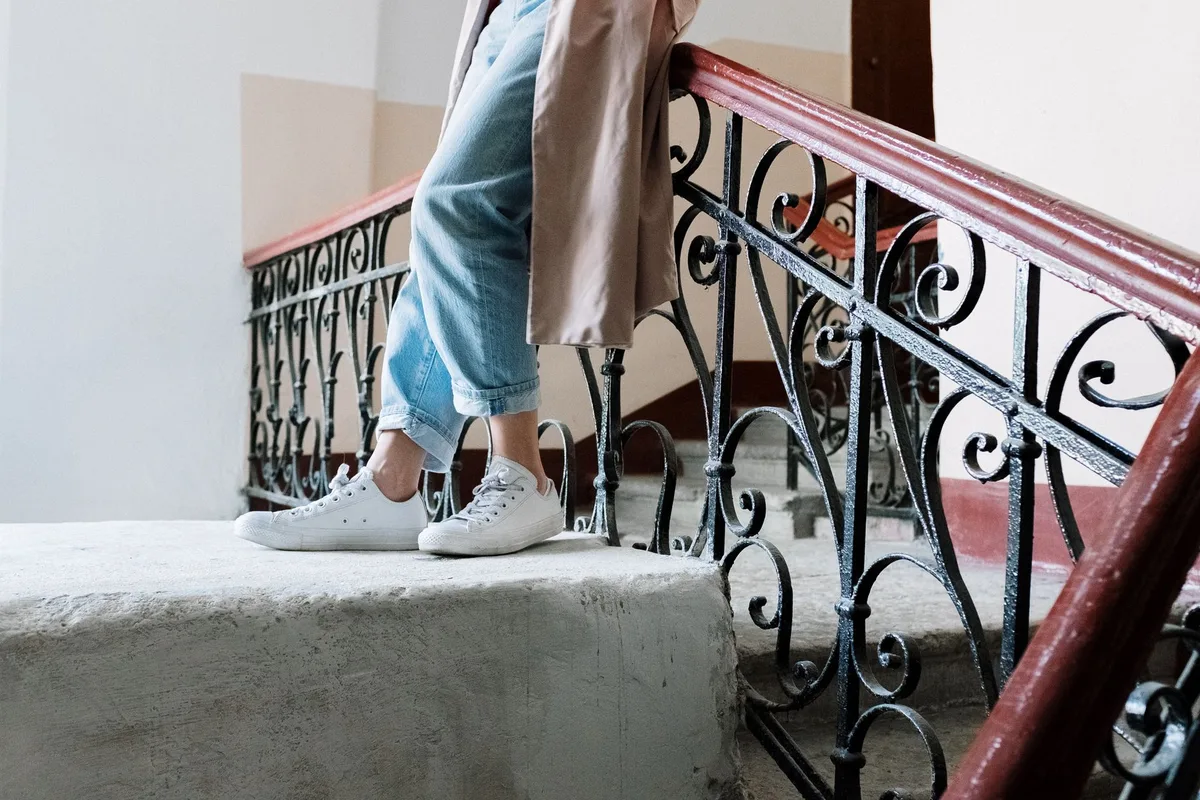 Femme en tenue décontractée avec trench court, jean et baskets pour la journée