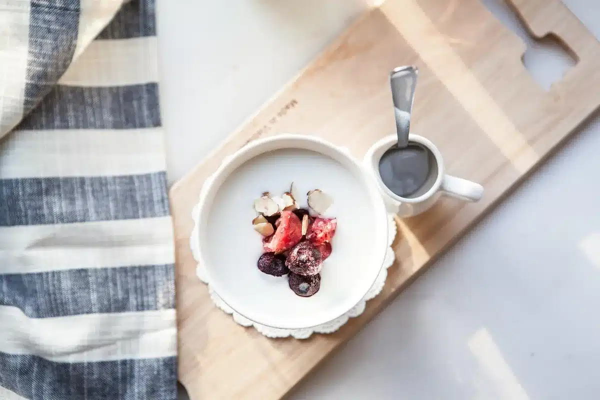 Parfait au yaourt sans lactose garni de fruits frais et cannelle dans un verre