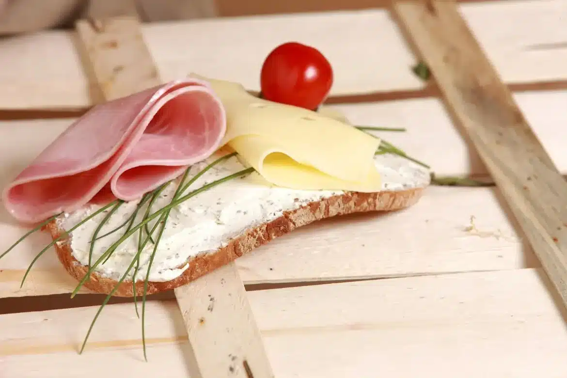 Préparation de collations saines avec légumes, fruits et noix sur une planche en bois dans une cuisine