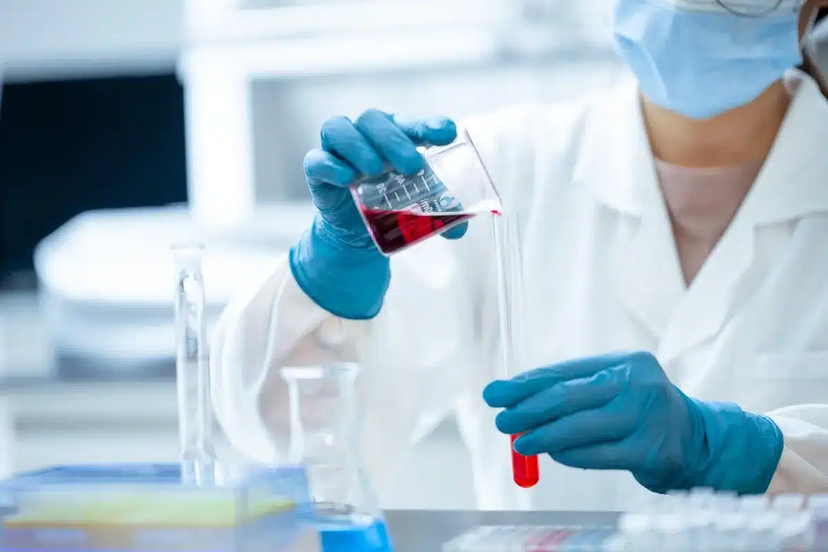 Technicien de laboratoire manipulant échantillons et visualisations génomiques