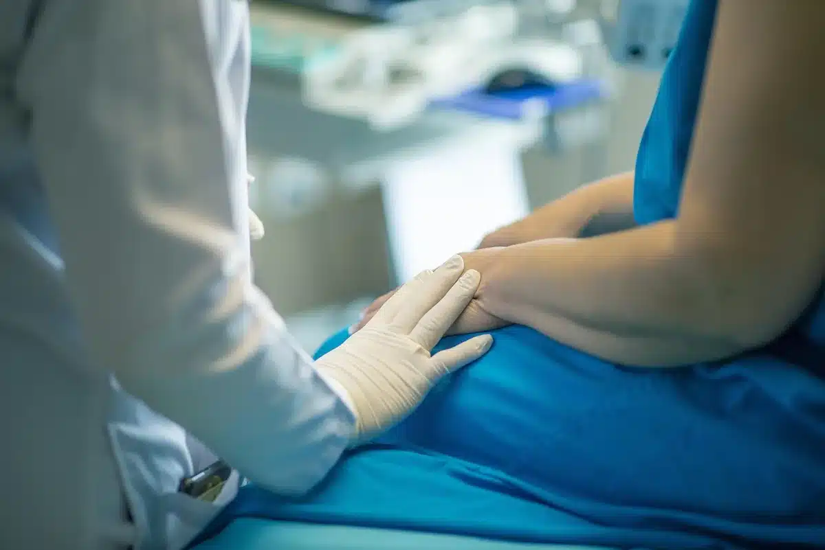 Professionnel de santé écoutant attentivement une patiente dans un cadre hospitalier