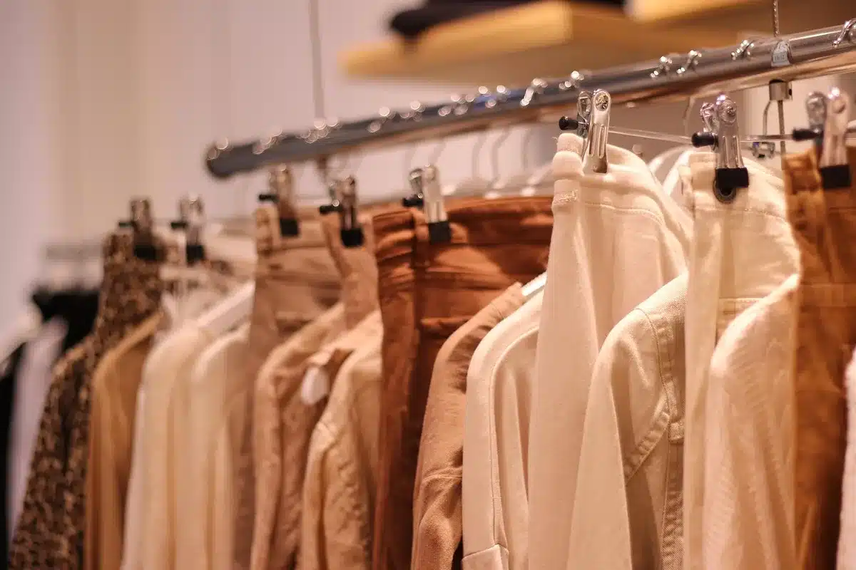 Capsule de vêtements automne disposés sur un lit avec manteau, hoodie et chaussures
