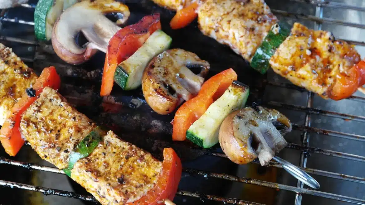 Assiette avec viande maigre grillée, légumes frais et herbes aromatiques sur table en bois