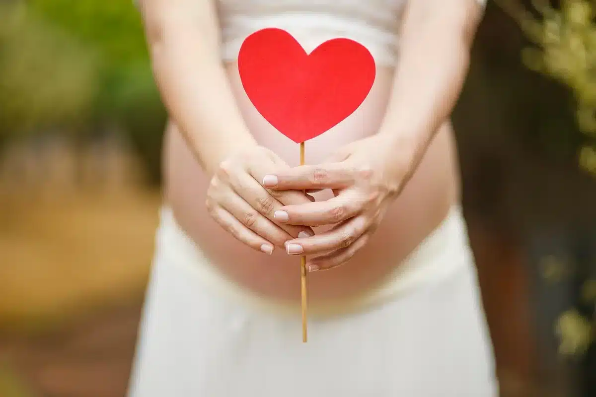 Femme enceinte discutant d'un traitement avec une pharmacienne près d'une étagère