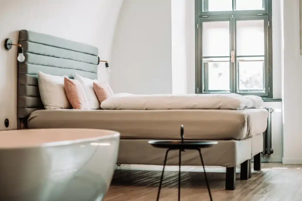 Chambre d'hôtel en journée avec dossiers médicaux et valise ouverte