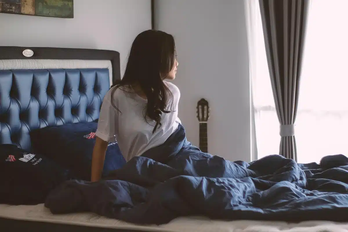 Personnes relaxées dans un lit éclairé par la lumière du jour