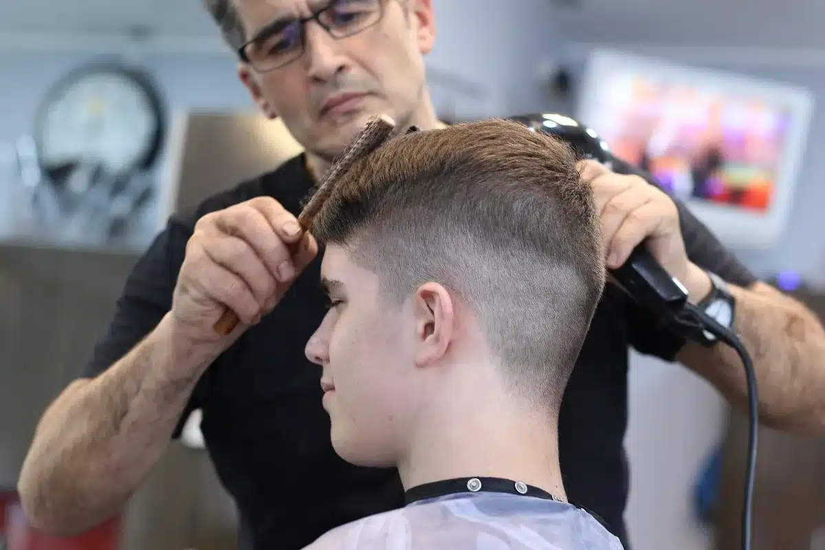 Coiffeur travaillant sur cheveux fins pour créer du volume au carré dégradé